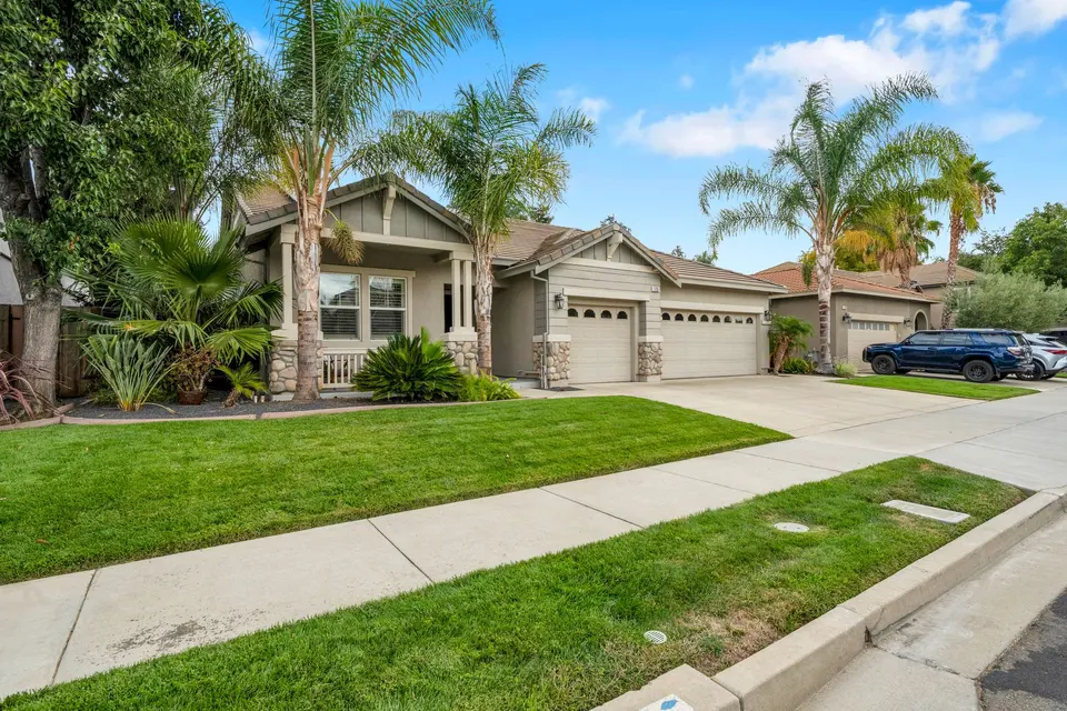 Street-facing view of the front lawn, covered porch and three-car garage at 173 Pescara Boulevard.