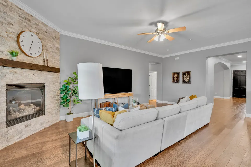 Reverse view of the family room with its sofa, television wall and stone fireplace.