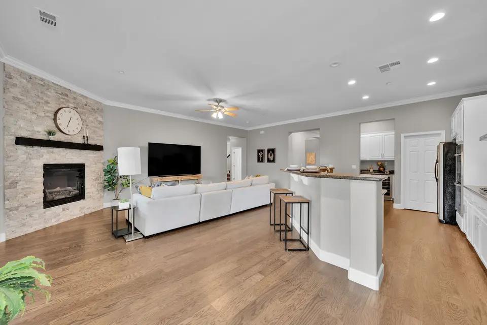 Open kitchen breakfast bar facing the family room and its stone fireplace.