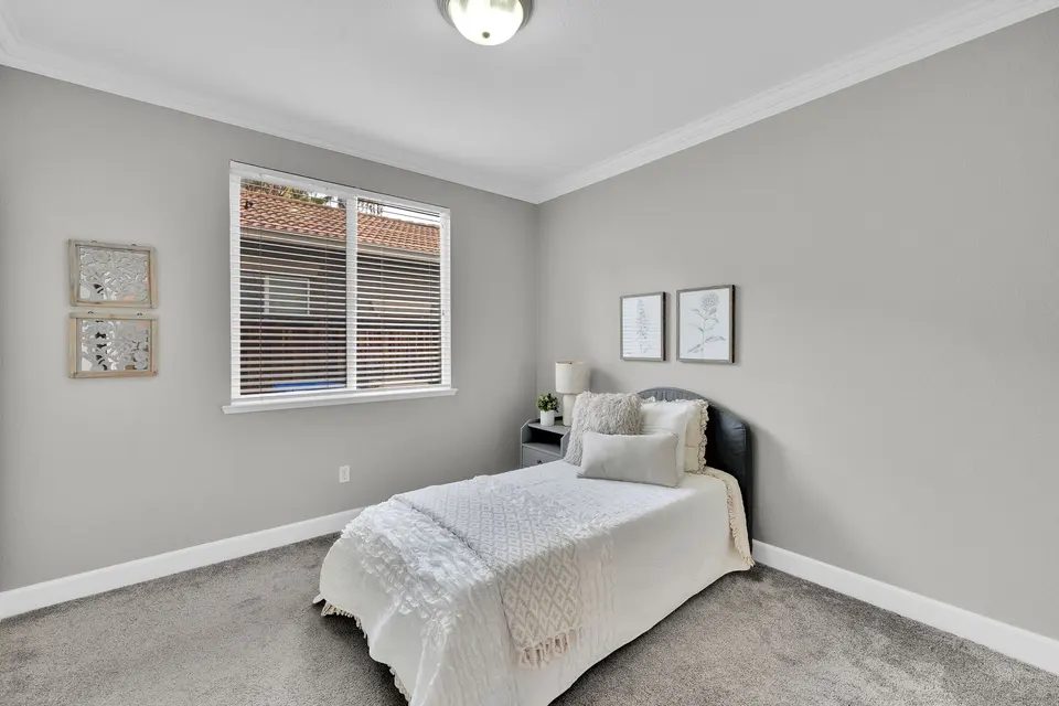 Secondary bedroom with a window, closet and a single bed arranged along one wall.