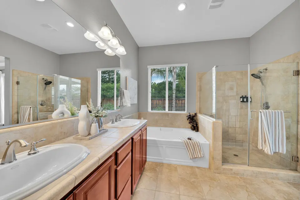 Primary bathroom with two sinks, a soaking tub and a separate glass-enclosed shower.