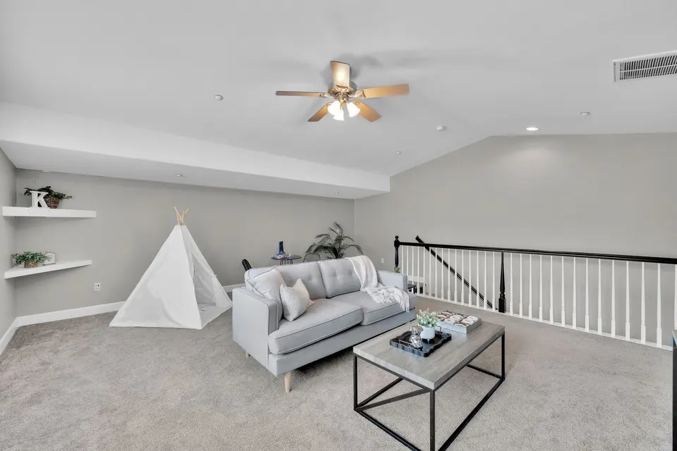 Upstairs loft seating area beside the open stair railing and storage closet.
