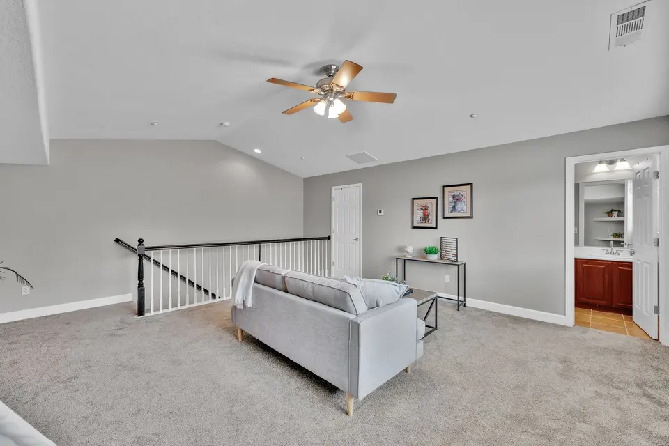 Upstairs loft showing the stair railing, seating area and entry to its adjoining bathroom.