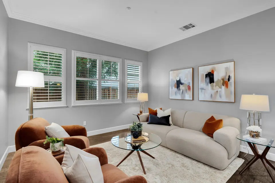 Front living area with shuttered windows, a sofa and accent chairs.