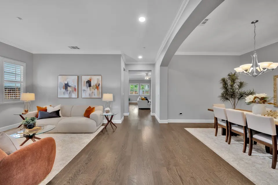 Front living and dining areas connected by an open passage with an arched ceiling detail.